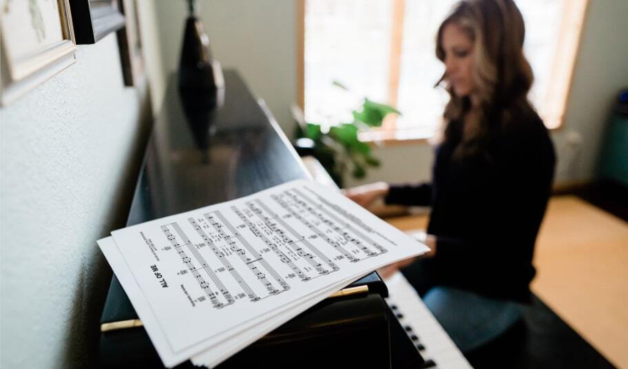 正在弹奏的直立钢琴之上的印刷乐谱